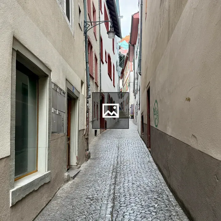 Narrow cobblestone street with red and white facades