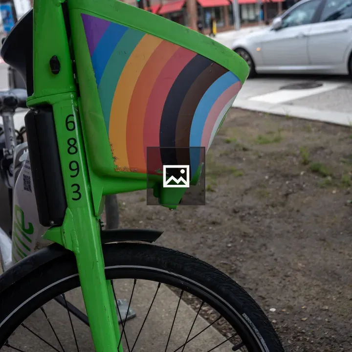 Green bicycle with rainbow flag basket