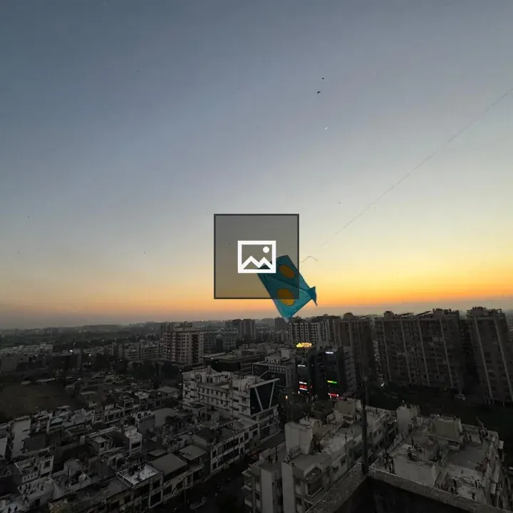 Blue kite over city sunset