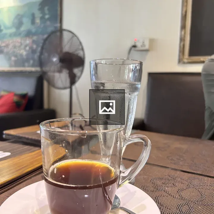 Glass of black coffee on saucer
