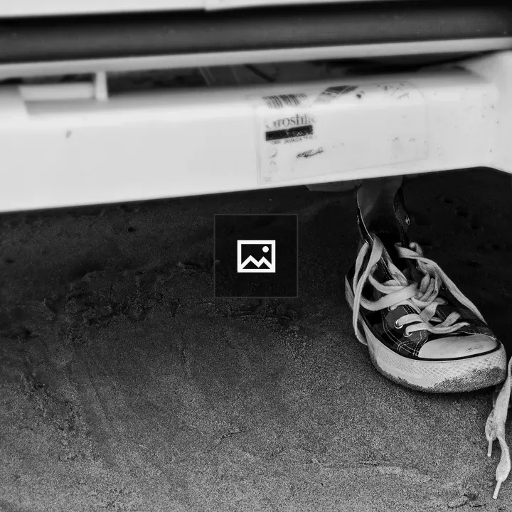 Sand-filled sneakers under beach loungers
