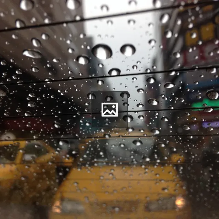 Raindrops on car window with taxis