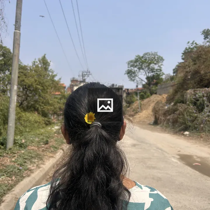 Person with ponytail and yellow flower