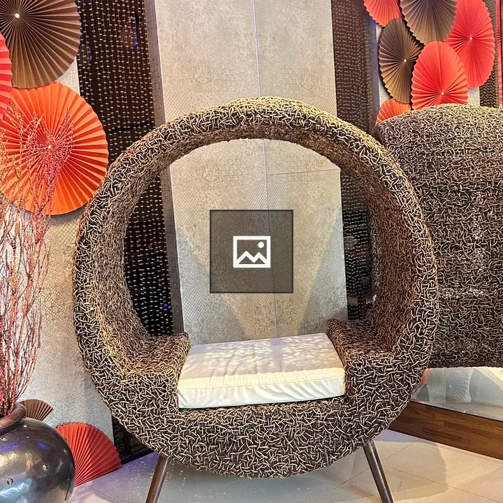 Circular woven chair with white cushion