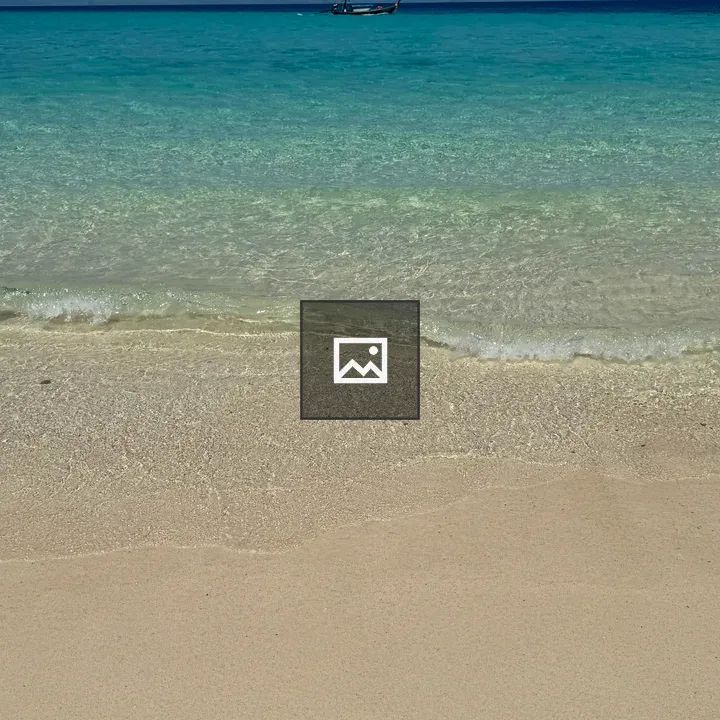 Beach scene with small boat on horizon