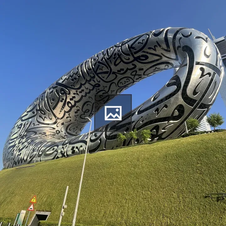 Silver ring-shaped building with Arabic calligraphy