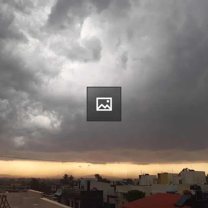 Dramatic sunset over roofs and clouds