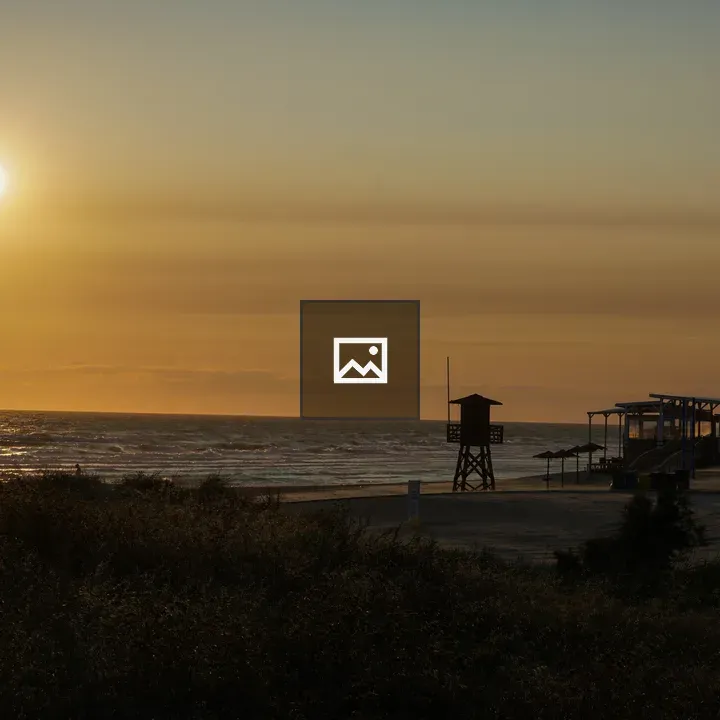 Sunset over an empty beach with a watchtower