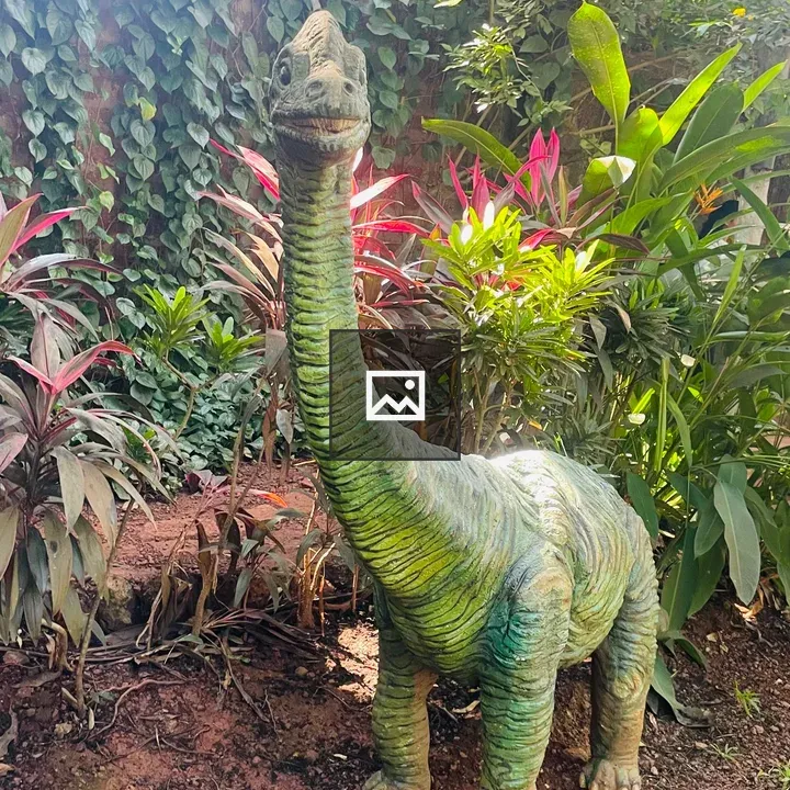 Green dinosaur sculpture in garden