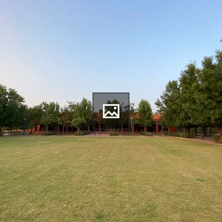 Green lawn leading to red-roofed building
