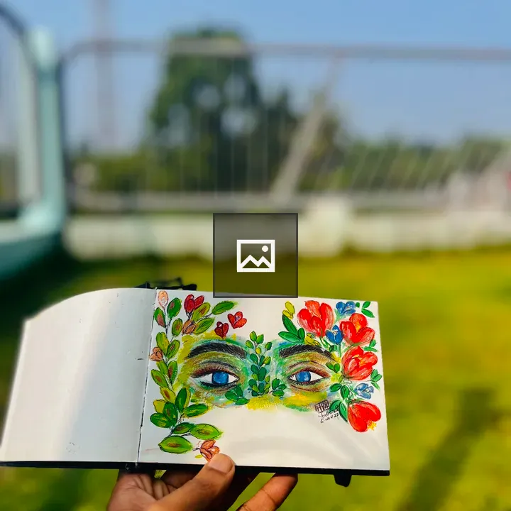 Hand Holding Notebook with Eye Sketches
