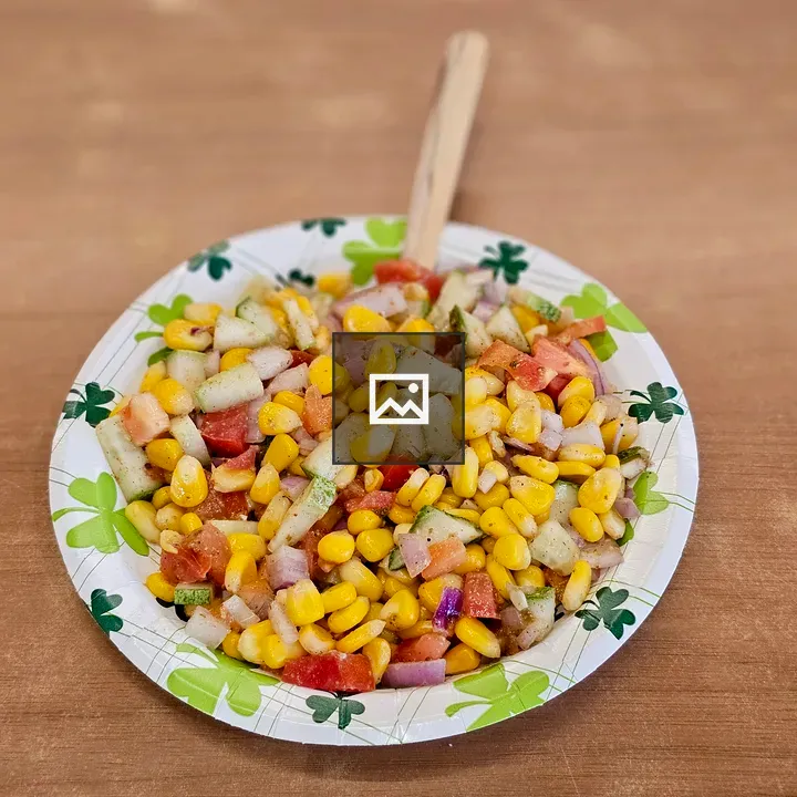 Colorful corn salad on paper plate