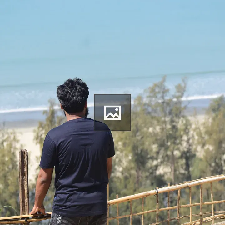 Man Looking Over Ocean from Fence