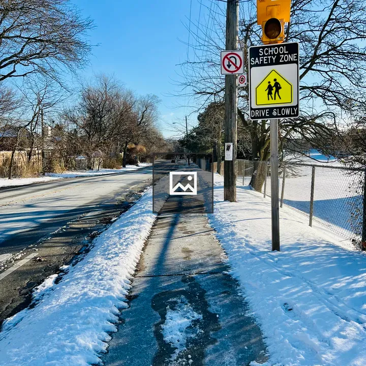 Snowy Sidewalk With School Sign