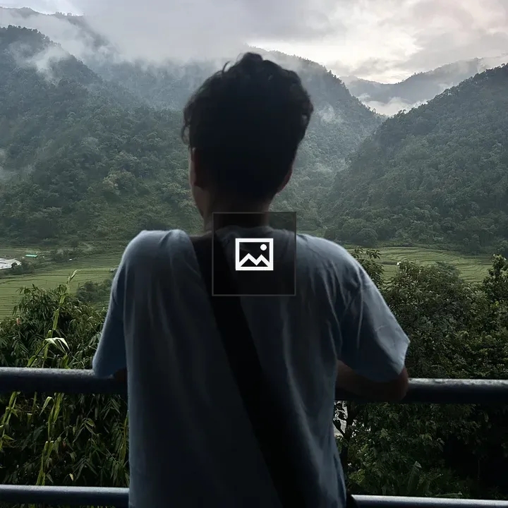 Person on Balcony Facing Misty Mountain
