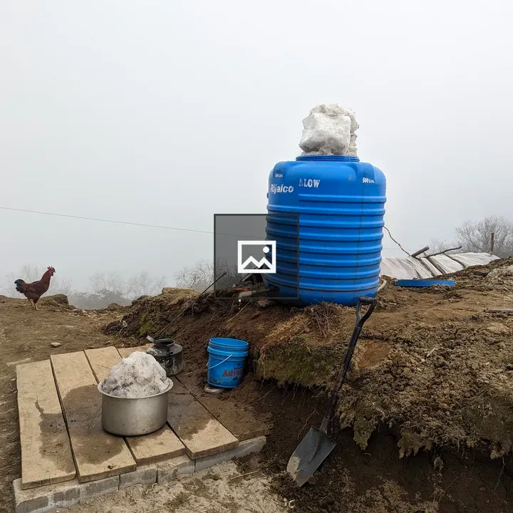 Blue water tank on snowy rural scene