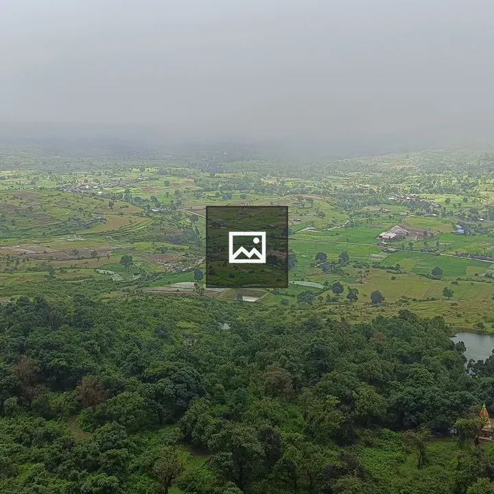 Panoramic fields with houses under clouds