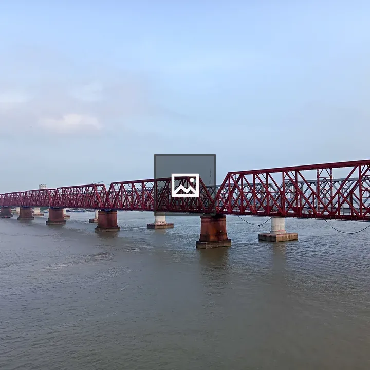 Long red steel railway bridge