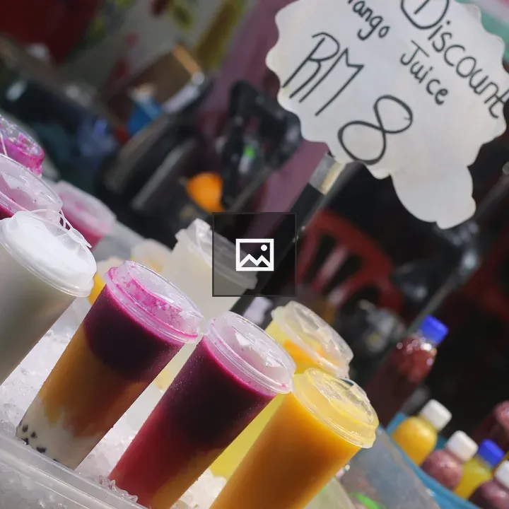 Colorful fruit juice cups at market stall