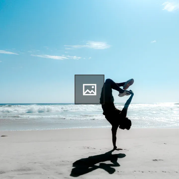 Silhouette one-hand handstand on beach