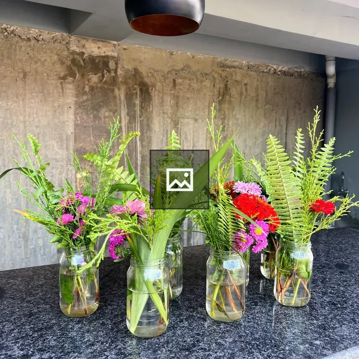Row of glass jar vases with flowers