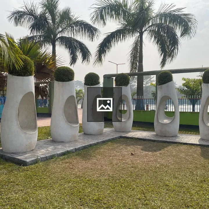 Six white oval sculptures on grass