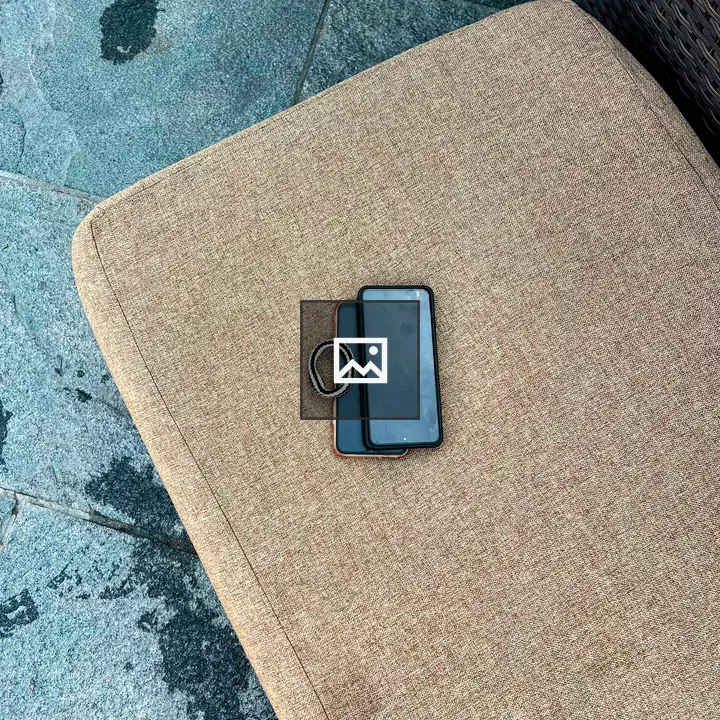 Two smartphones on chair cushion