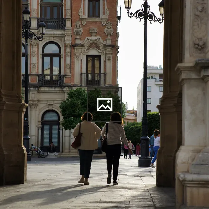 Two women under a stone arch in Seville