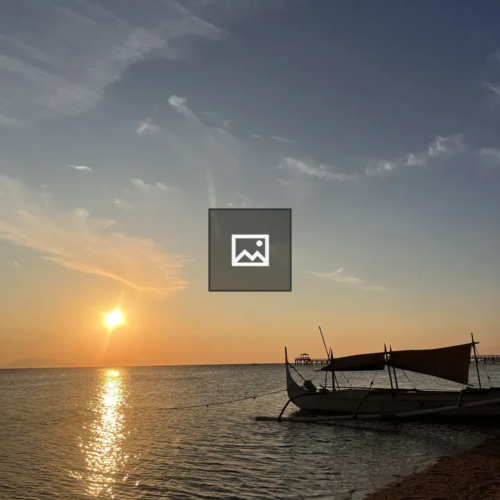 Sunset over calm sea with boat