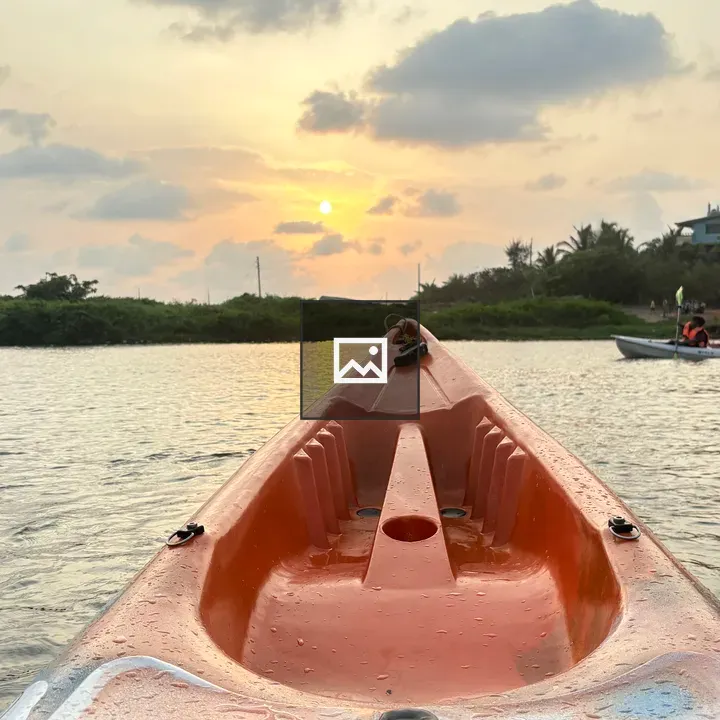 Orange kayak on water at sunset