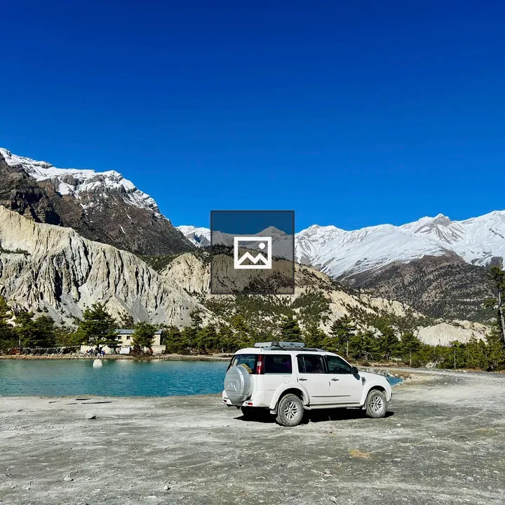 White SUV by Blue Lake in Manang