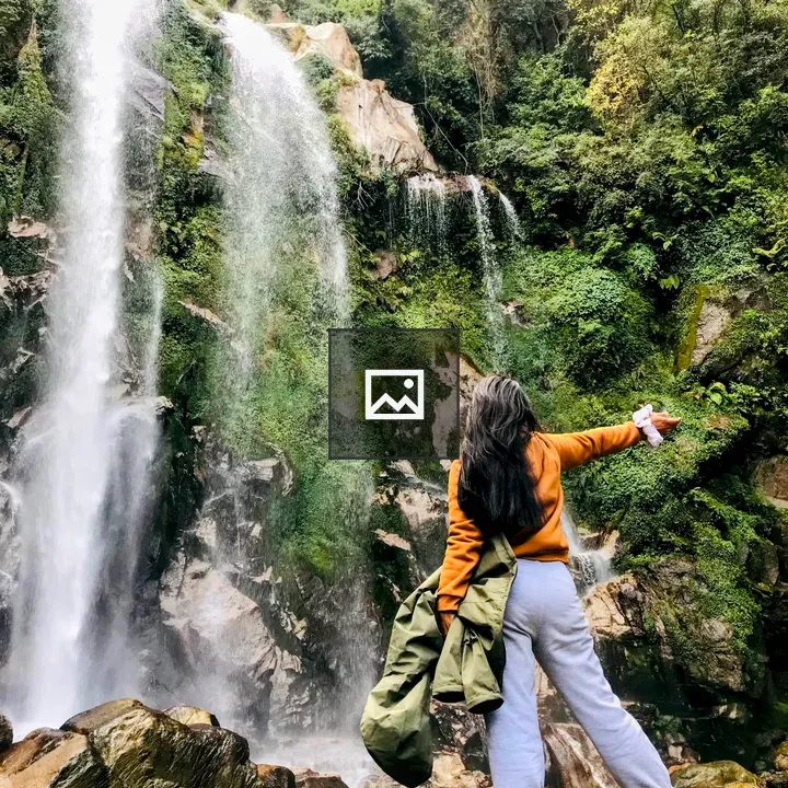 Back view of a person by a waterfall
