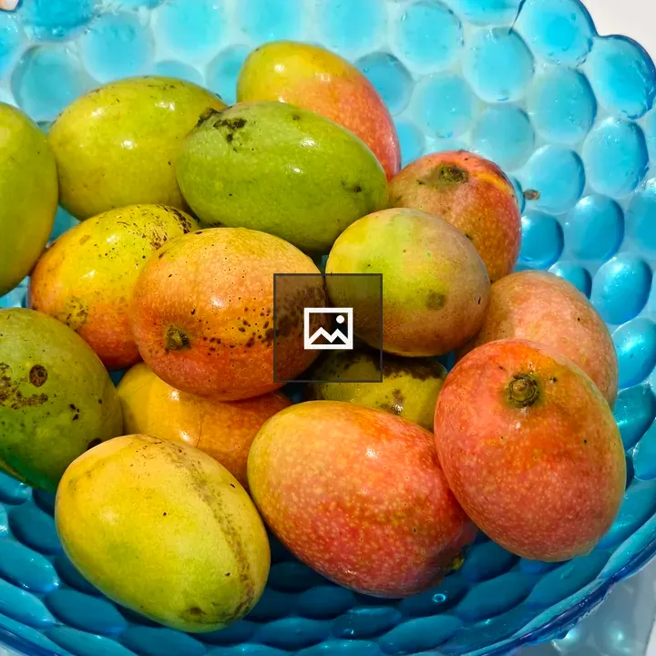 Blue glass bowl with mangoes