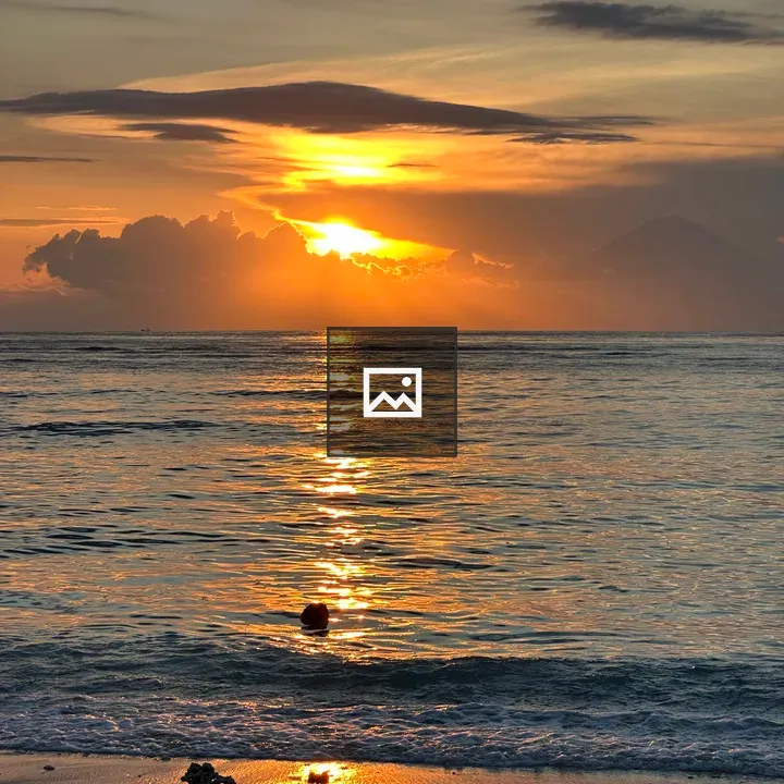 Sunset over calm ocean shore