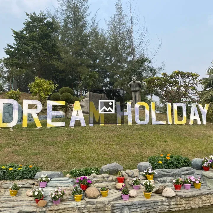 Dream Holiday sign on grassy hill