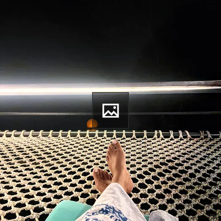 Bare feet relaxing in hammock at night