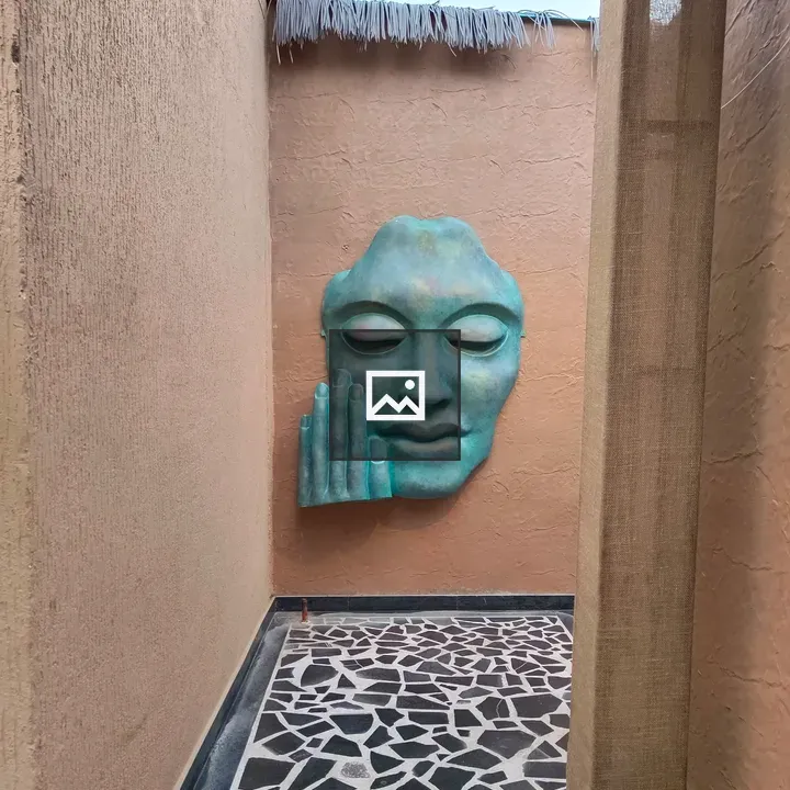 Turquoise sculptural face on peach wall