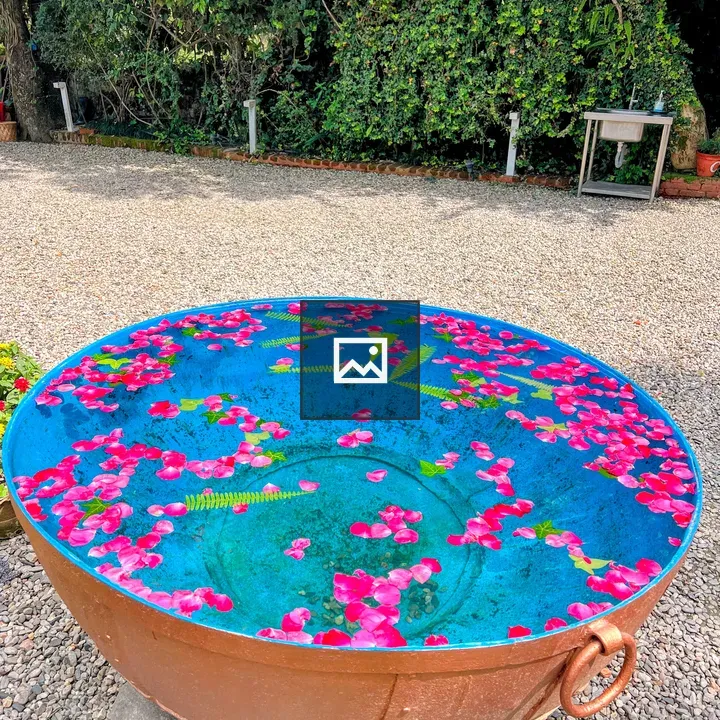 Copper bowl with blue water and petals