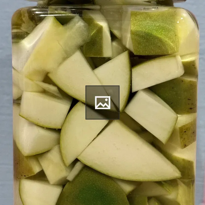 Raw mango pieces in glass jar