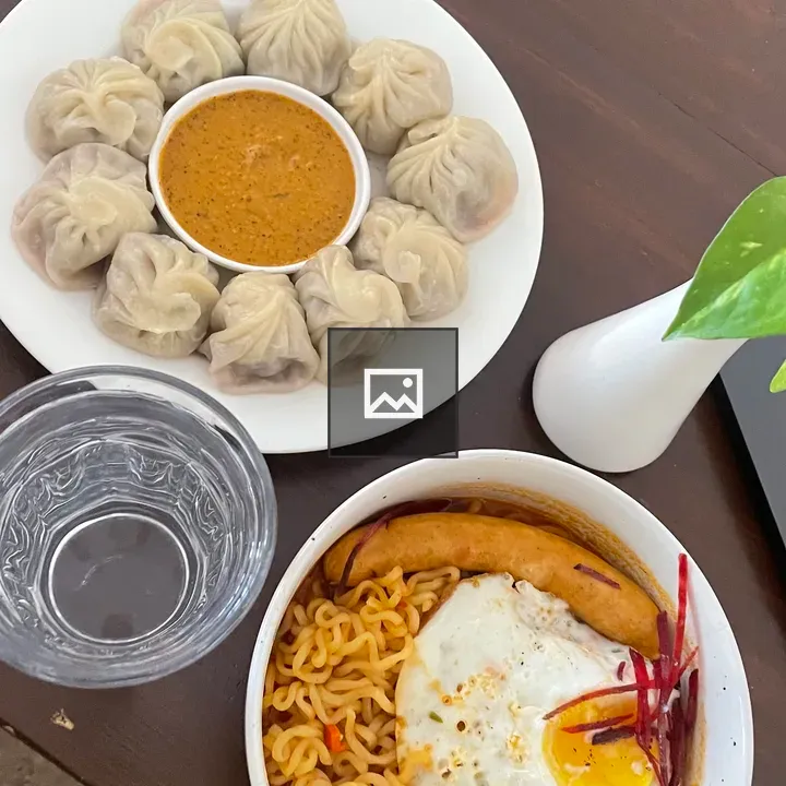 Two-dish table setting with momo and noodles