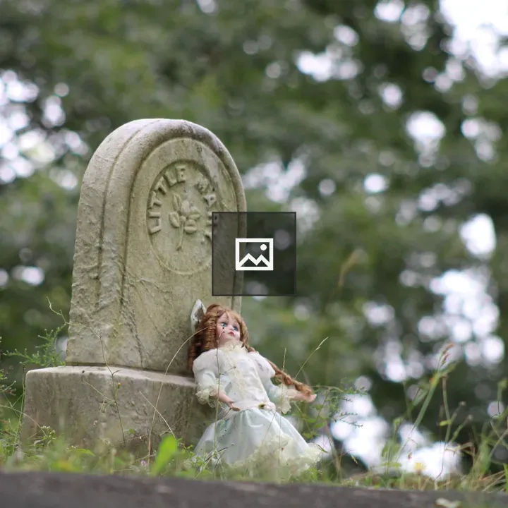 Porcelain Doll on Grave Marker