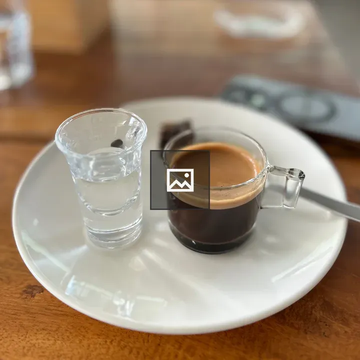 Glass of water with espresso and chocolate