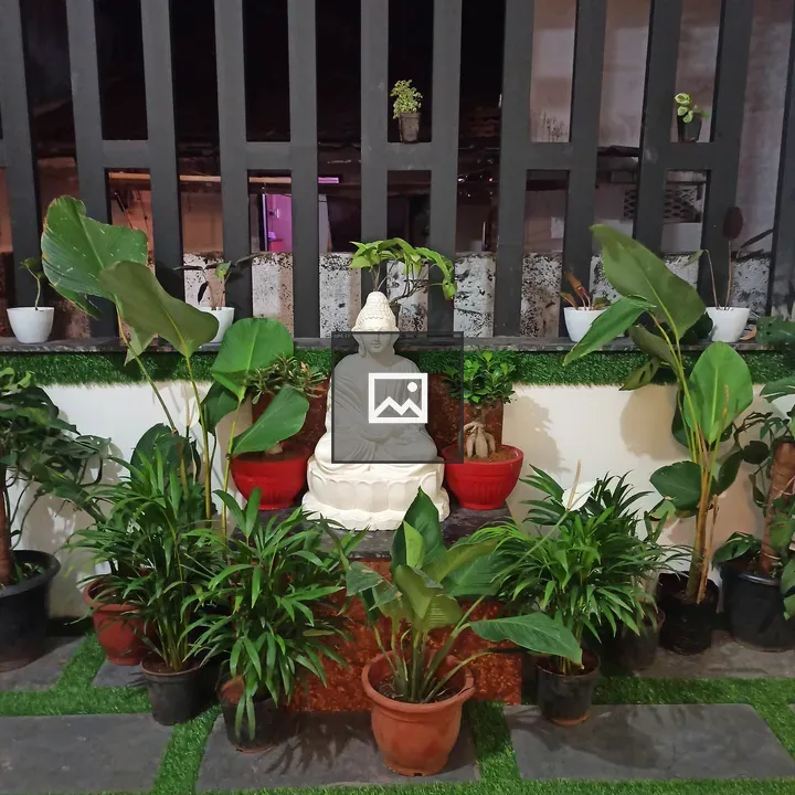 White Buddha statue surrounded by plants