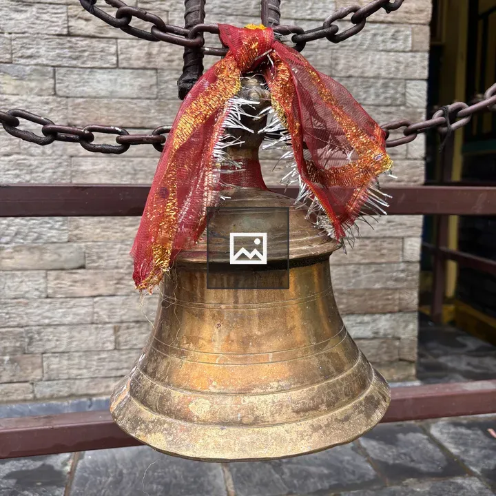 Brass temple bell with red cloth