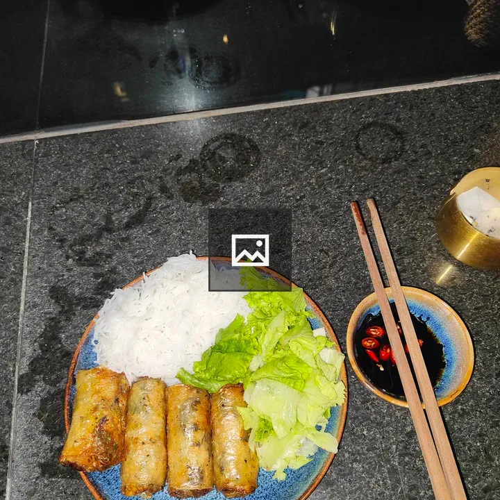 Blue plate with spring rolls and noodles