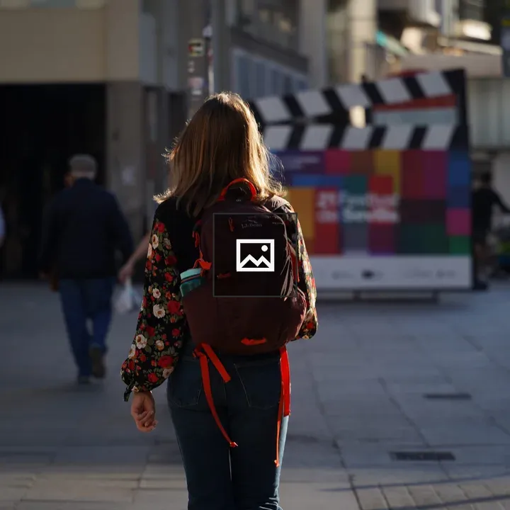 Person Walking with Backpack on City Street