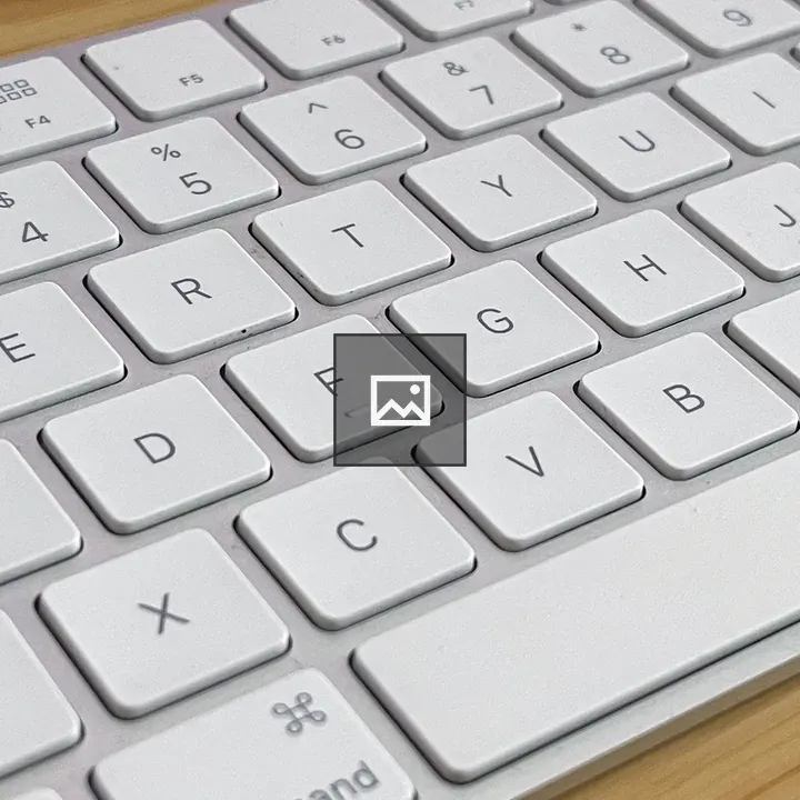 White Apple Keyboard on Bamboo Desk