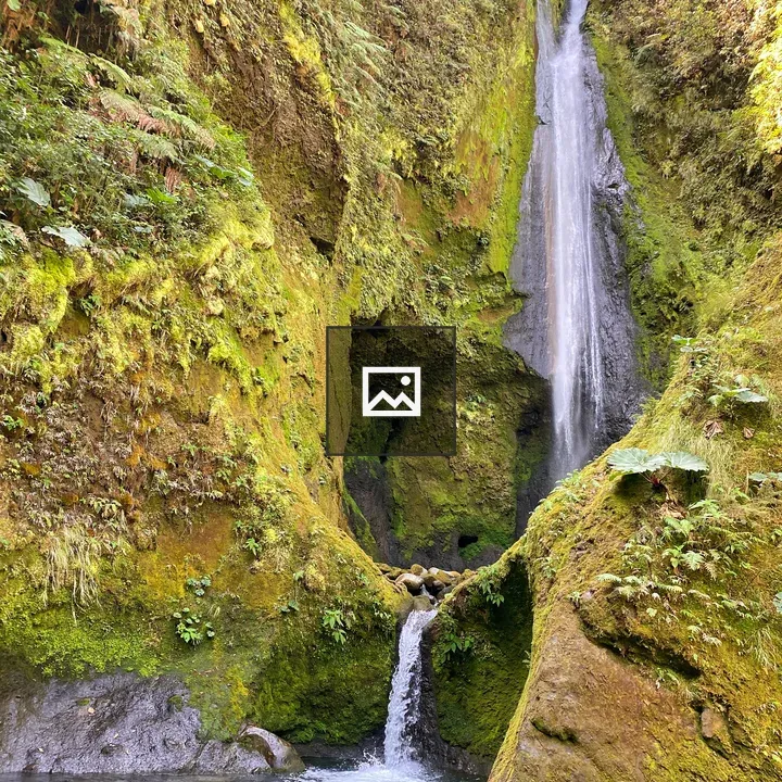 Waterfall Cascades Over Mossy Rock