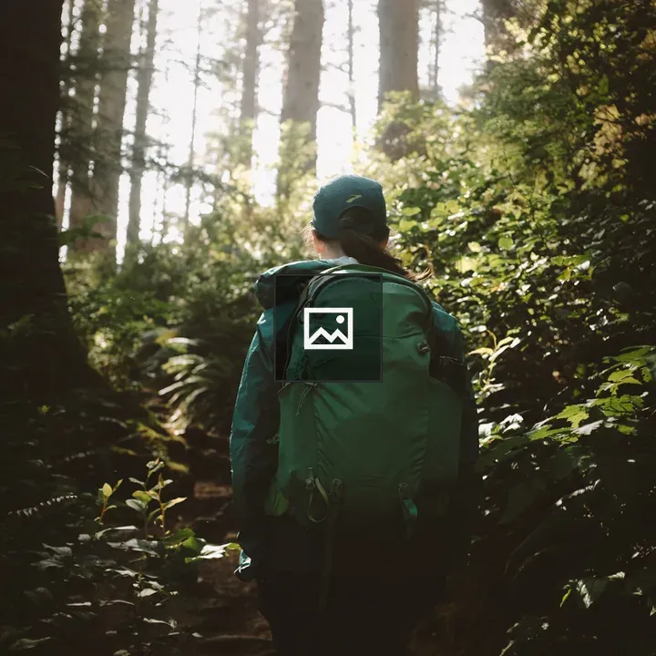 Person with hat and backpack in forest