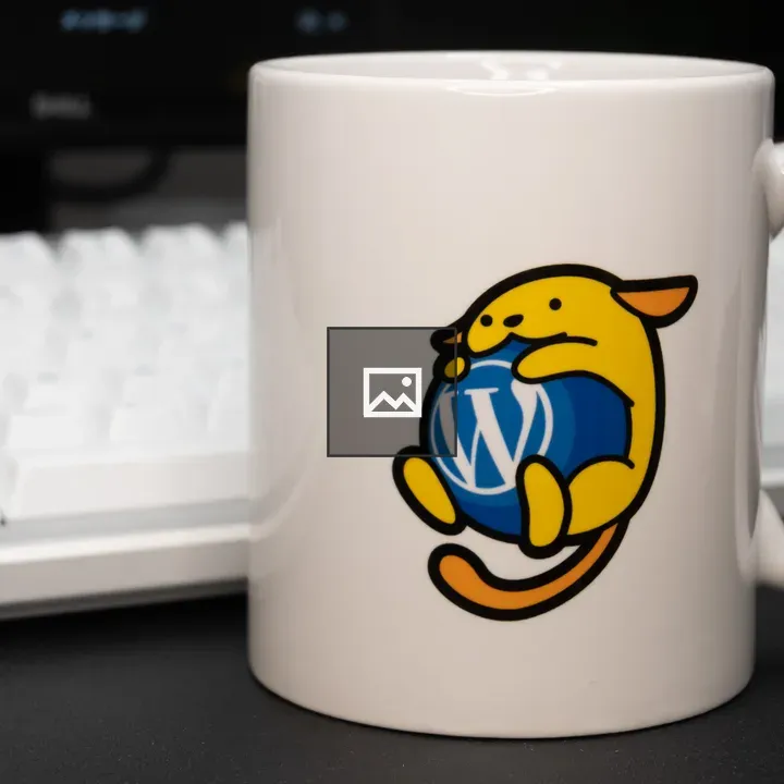 White mug with Wapuu and WordPress logo